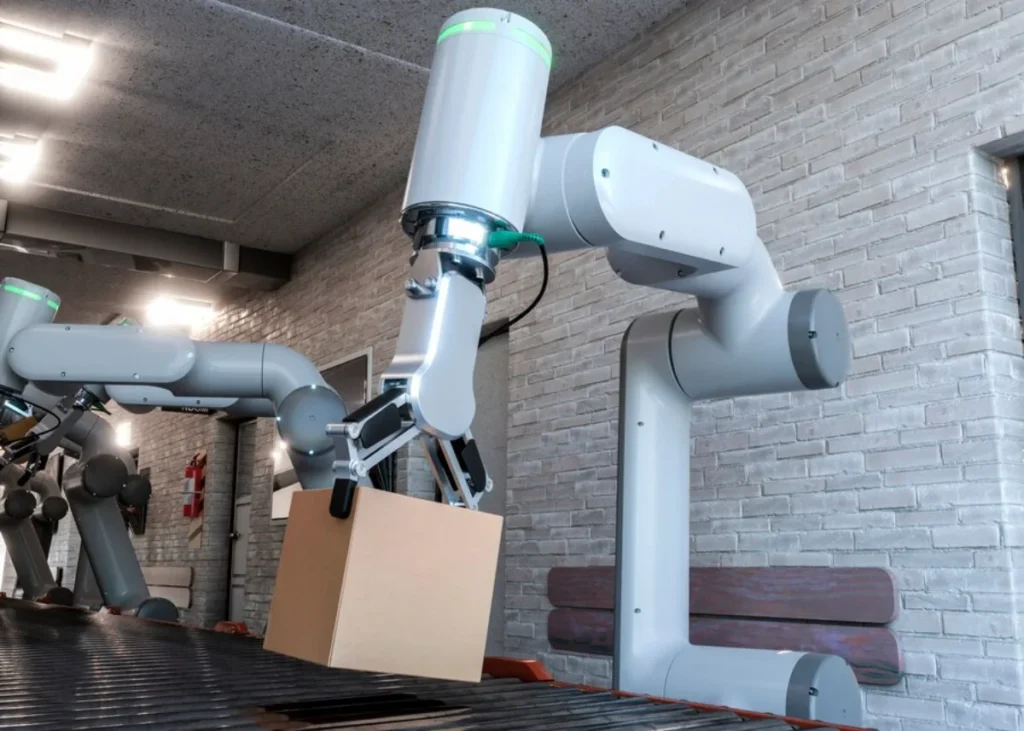 An industrial robot with articulated arms packing items into a cardboard box in a warehouse setting.